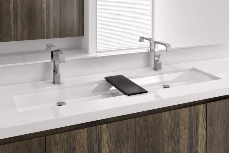 Undermount sinks by Wetstyle. Large rectangular sink with double faucets and wood bridge between them.